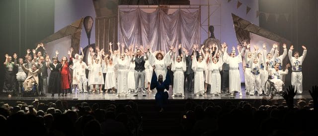 The academy company waves to the audience in the theatre